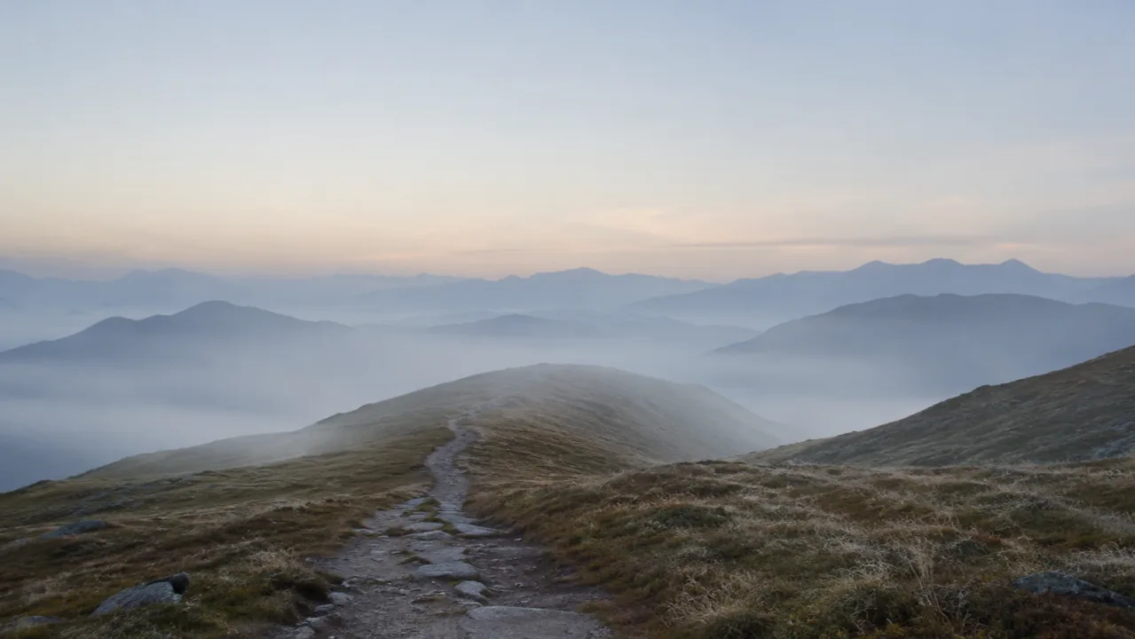 Stone path leading into a misty mountain landscape at dawn.